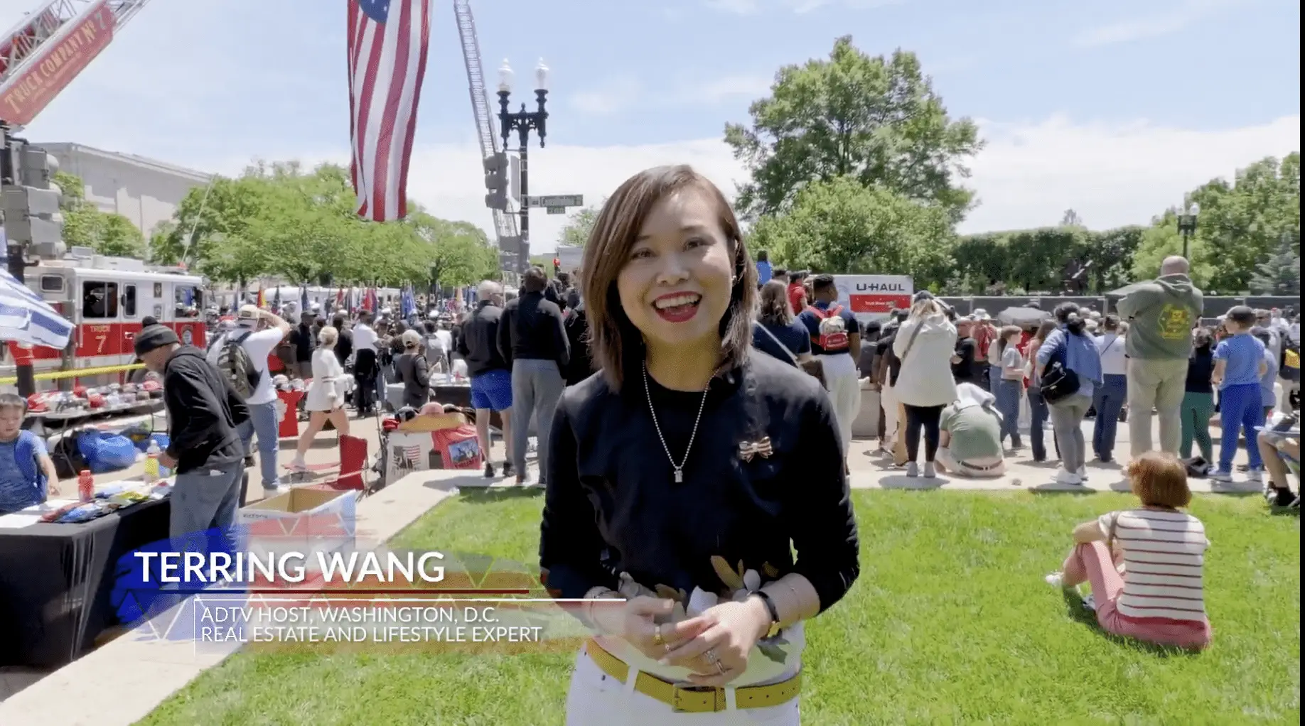 Smiling woman at outdoor event with crowd.
